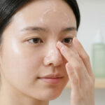 Jeune femme appliquant un gel de soin sur son nez pour traiter les points noirs.